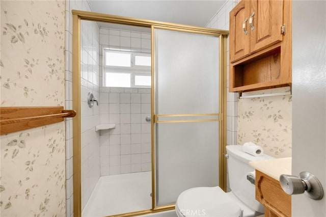 full bath with vanity, a shower stall, toilet, and wallpapered walls