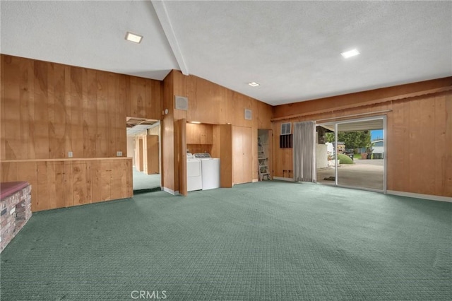 unfurnished living room featuring carpet floors, wooden walls, a textured ceiling, and independent washer and dryer