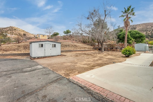 view of yard featuring a shed, a mountain view, and an outdoor structure