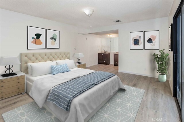 bedroom with baseboards, ensuite bathroom, visible vents, and light wood-style floors