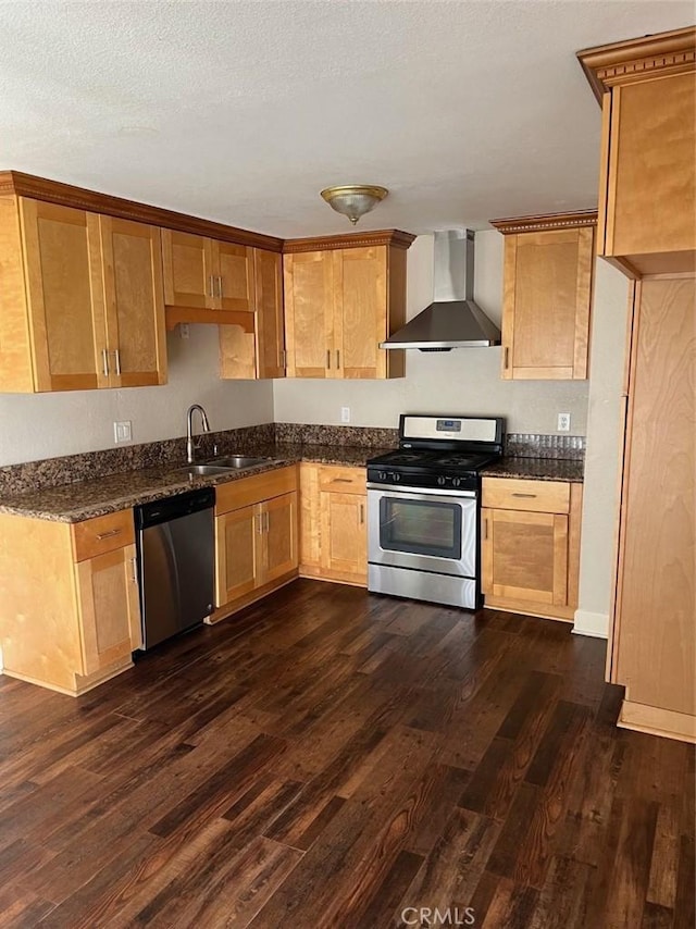 kitchen featuring a textured ceiling, a sink, appliances with stainless steel finishes, wall chimney exhaust hood, and dark wood finished floors