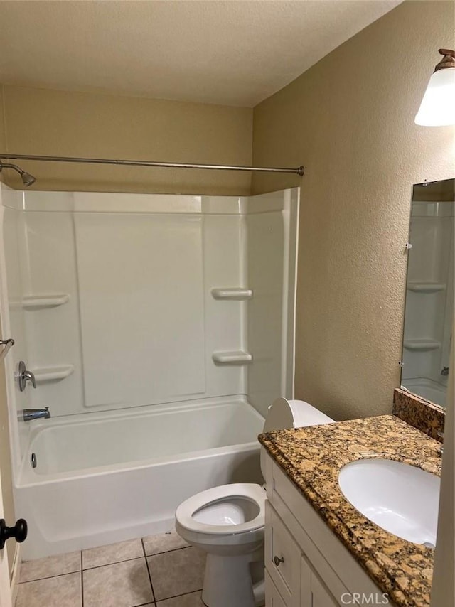 bathroom with a textured wall, shower / tub combination, toilet, tile patterned flooring, and vanity