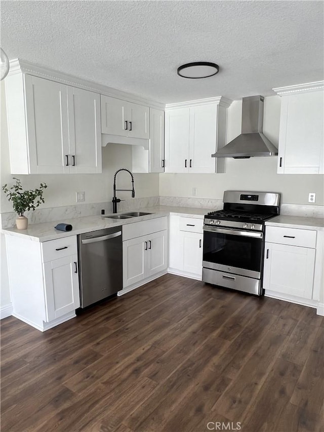 22822 Mesa Way Unit 1, Lake Forest, CA 92630 - kitchen with wall chimney exhaust hood, appliances with stainless steel finishes, a textured ceiling, white cabinets, and dark wood-style floors