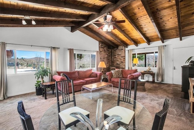 interior space featuring vaulted ceiling with beams, ceiling fan, wood ceiling, and a wood stove