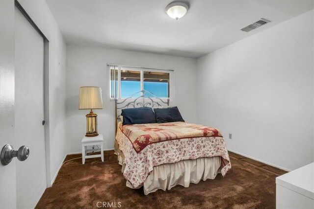 carpeted bedroom featuring visible vents