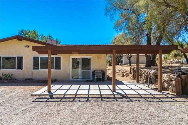 rear view of property with a patio area and stucco siding