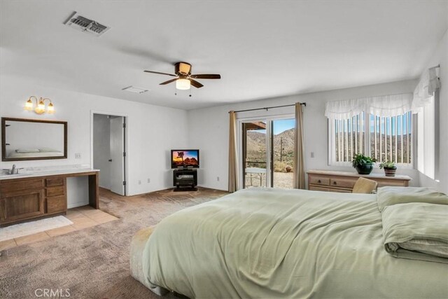 bedroom with visible vents, a ceiling fan, light colored carpet, access to exterior, and a sink