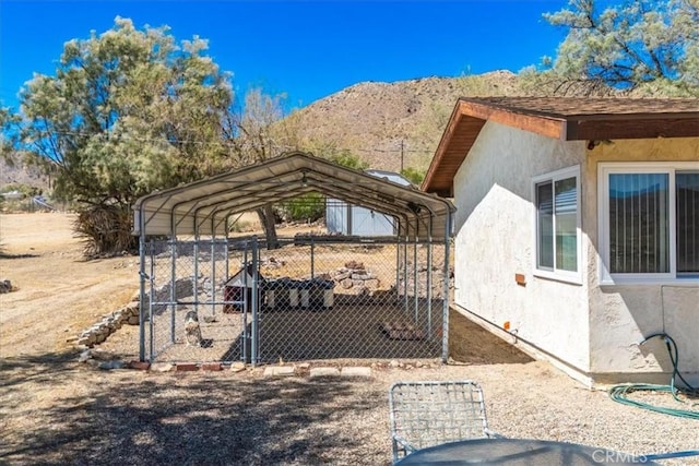 view of property exterior with a carport, a mountain view, and stucco siding