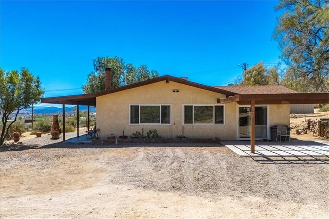 back of property featuring a patio and stucco siding