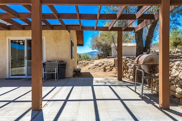 view of patio with exterior kitchen, a grill, and a pergola