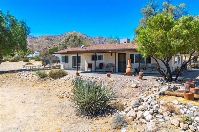 ranch-style house with a mountain view and a patio