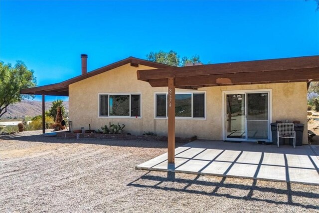 rear view of property featuring a patio and stucco siding