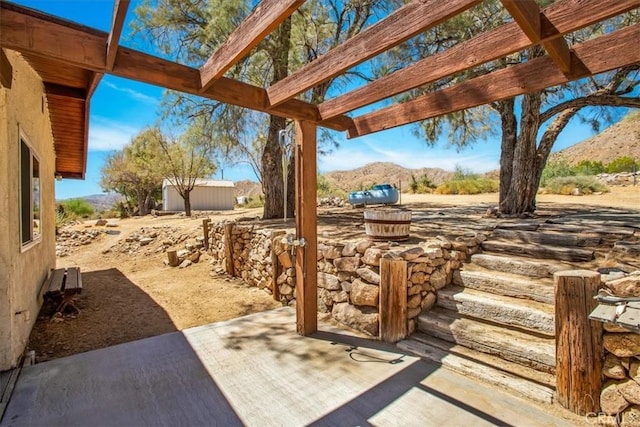 view of patio / terrace featuring an outbuilding and a mountain view