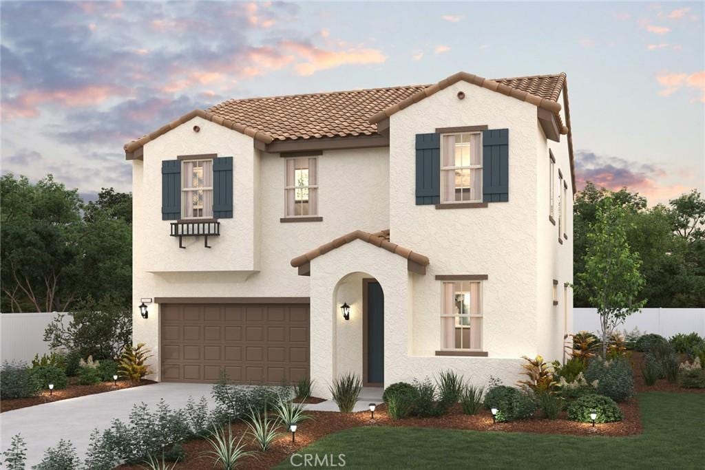 mediterranean / spanish home featuring a garage, a tile roof, and stucco siding