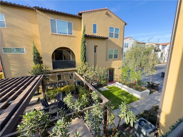 back of property with stucco siding and a tile roof