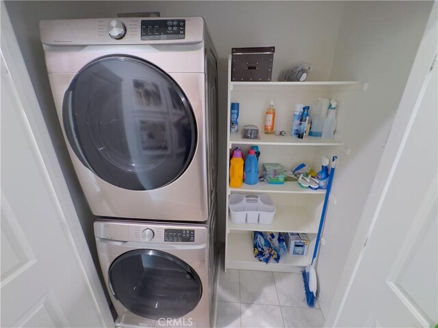 laundry room featuring tile patterned floors, stacked washer and dryer, and laundry area