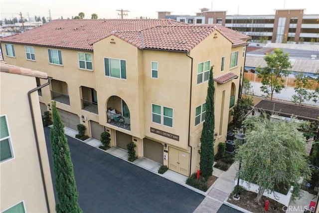 view of building exterior featuring an attached garage and driveway