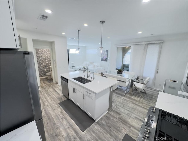 kitchen with a sink, visible vents, appliances with stainless steel finishes, and light countertops