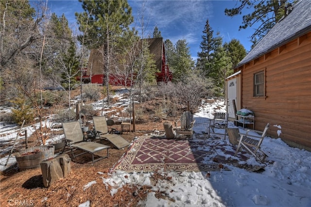 yard covered in snow featuring a patio