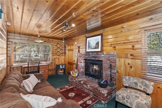 living area featuring carpet floors, wooden ceiling, a fireplace, and wooden walls