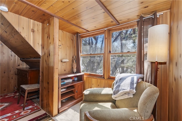 sitting room with carpet, wood walls, wooden ceiling, and a healthy amount of sunlight