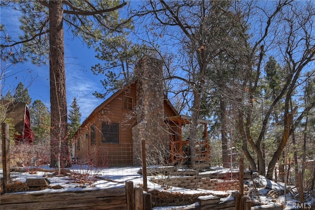 view of snowy exterior featuring a chimney