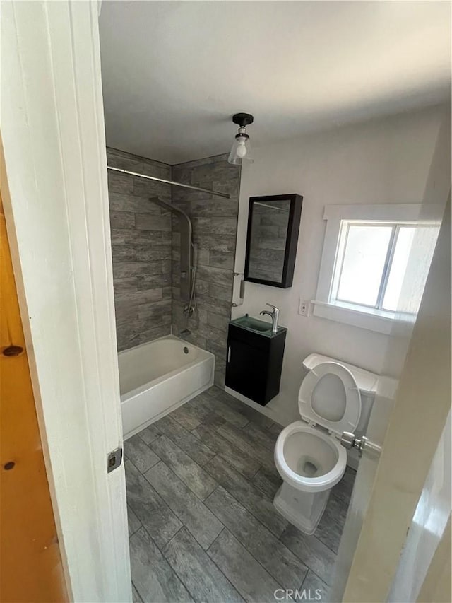 full bath featuring toilet, shower / bath combination, a sink, and wood finish floors