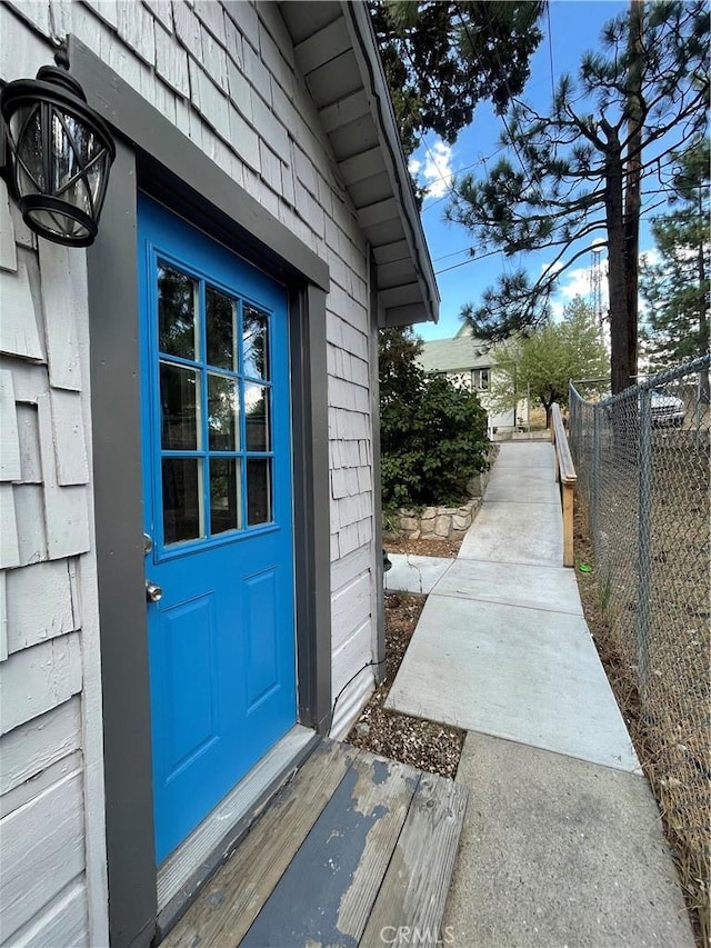 doorway to property featuring fence