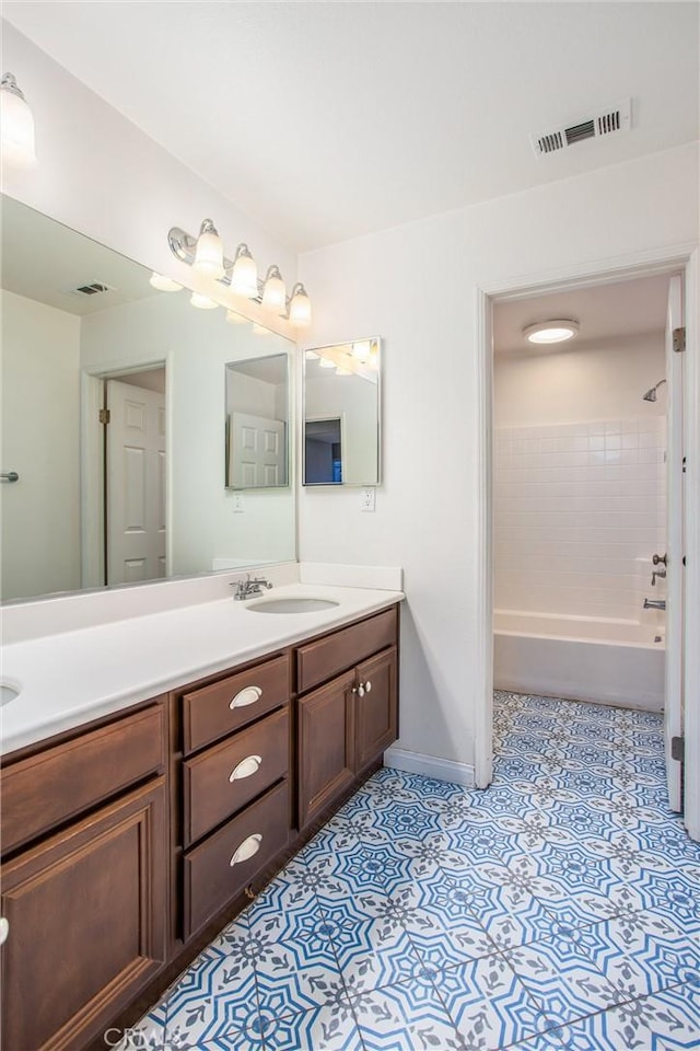 bathroom with tile patterned flooring, shower / bath combination, a sink, visible vents, and double vanity