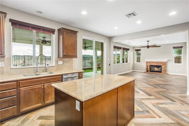 kitchen with dishwasher, backsplash, a sink, and visible vents