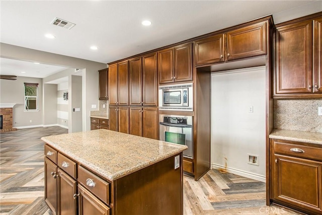 kitchen featuring appliances with stainless steel finishes, open floor plan, visible vents, and tasteful backsplash