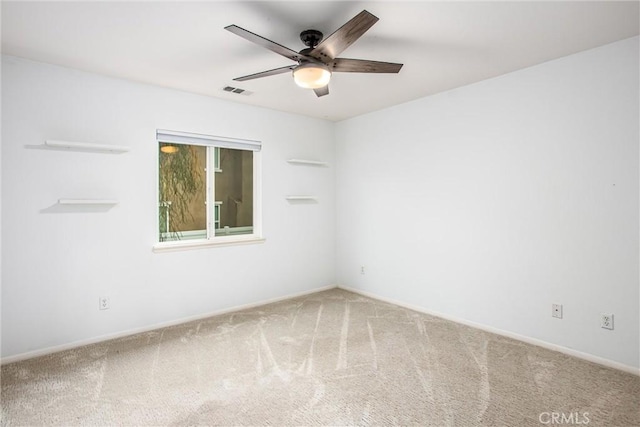 empty room with visible vents, a ceiling fan, and carpet flooring