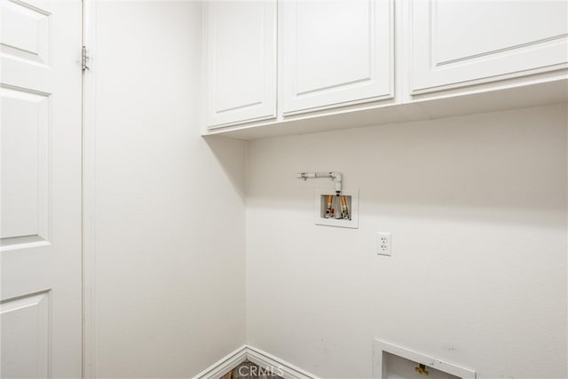 washroom with hookup for a washing machine, baseboards, and cabinet space