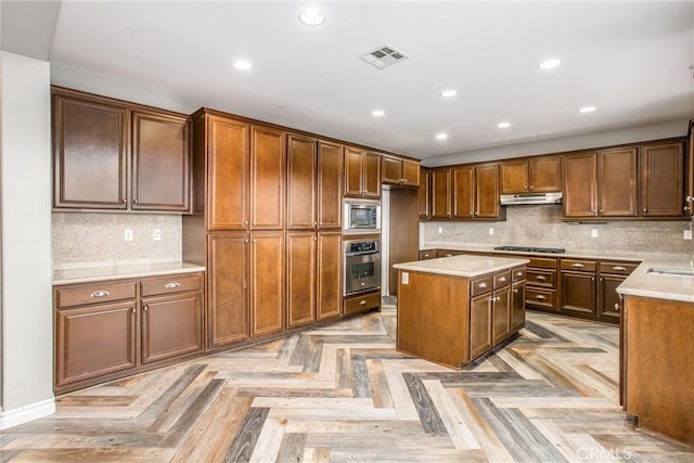 kitchen with recessed lighting, under cabinet range hood, stainless steel appliances, visible vents, and backsplash