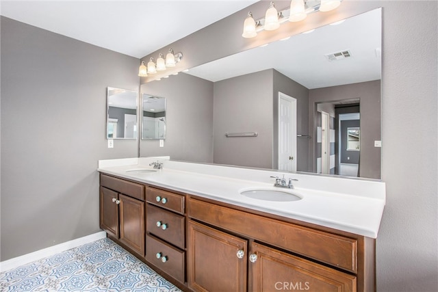 full bath with visible vents, a sink, baseboards, and double vanity