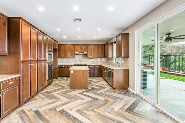 kitchen with stainless steel appliances, tasteful backsplash, visible vents, and under cabinet range hood