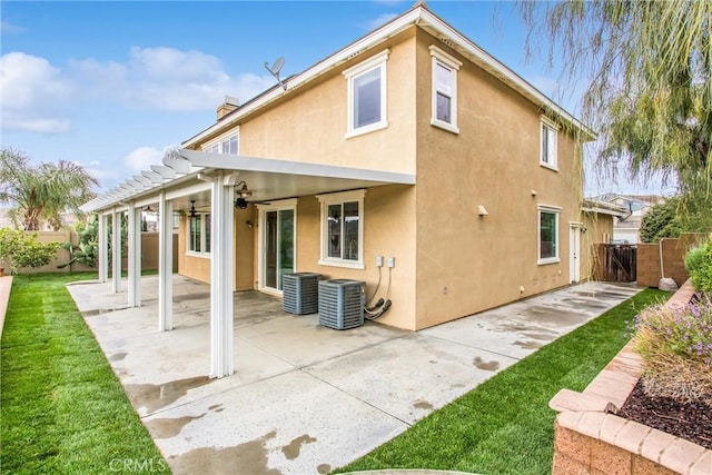 rear view of house featuring a ceiling fan, a patio area, fence, and stucco siding