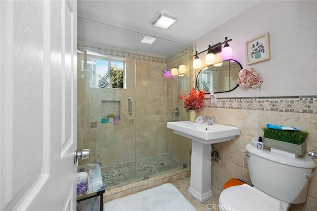 full bath featuring tile walls, toilet, and a stall shower
