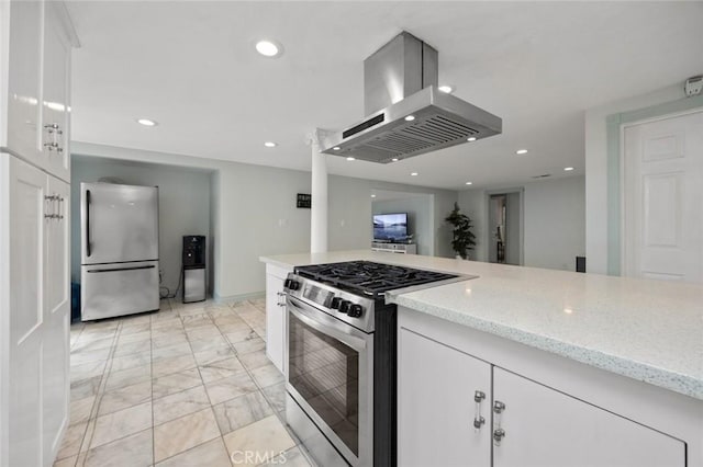 kitchen with light stone counters, island exhaust hood, appliances with stainless steel finishes, and white cabinetry