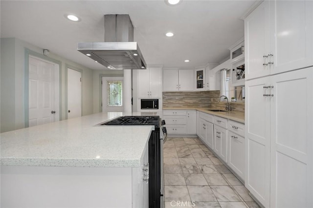 kitchen featuring marble finish floor, a sink, white cabinets, gas range, and extractor fan