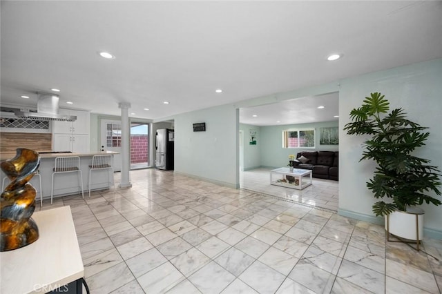 living room featuring recessed lighting, baseboards, marble finish floor, and ornate columns