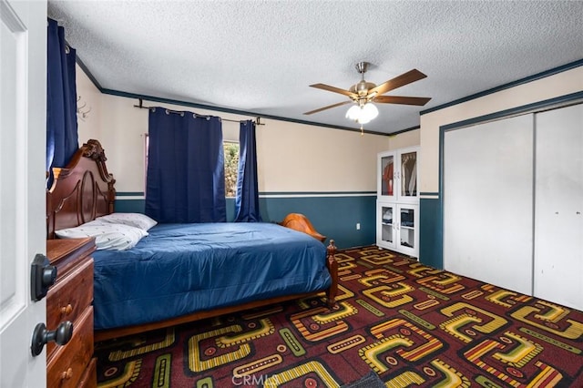 carpeted bedroom featuring ceiling fan, a textured ceiling, and a closet