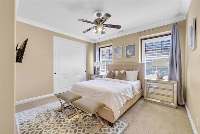 bedroom featuring light carpet, ornamental molding, a ceiling fan, a closet, and baseboards