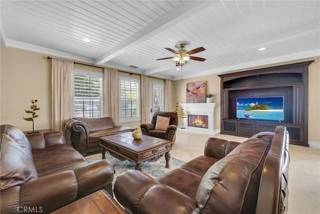 living room with baseboards, beam ceiling, wooden ceiling, a glass covered fireplace, and a ceiling fan