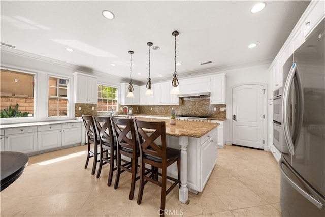 37 Shepard, Irvine, CA 92620 - kitchen featuring freestanding refrigerator, exhaust hood, white cabinetry, crown molding, and tasteful backsplash