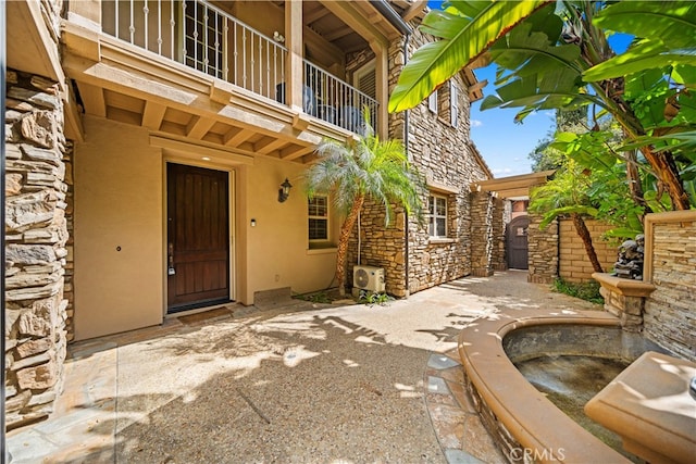37 Shepard, Irvine, CA 92620 - view of exterior entry with stone siding, a balcony, stucco siding, and a patio area