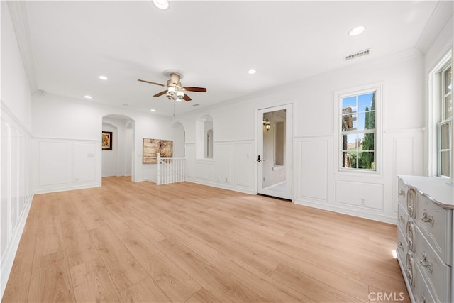 37 Shepard, Irvine, CA 92620 - unfurnished living room featuring a decorative wall, a ceiling fan, light wood-type flooring, ornamental molding, and arched walkways