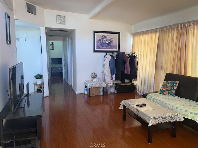 interior space with beam ceiling, visible vents, and wood finished floors