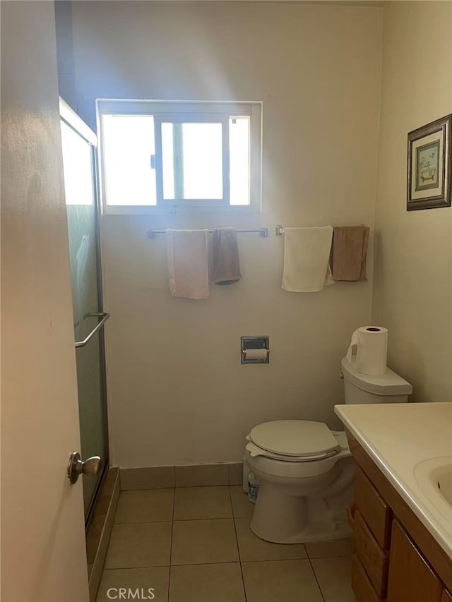 full bathroom featuring toilet, a stall shower, vanity, and tile patterned floors