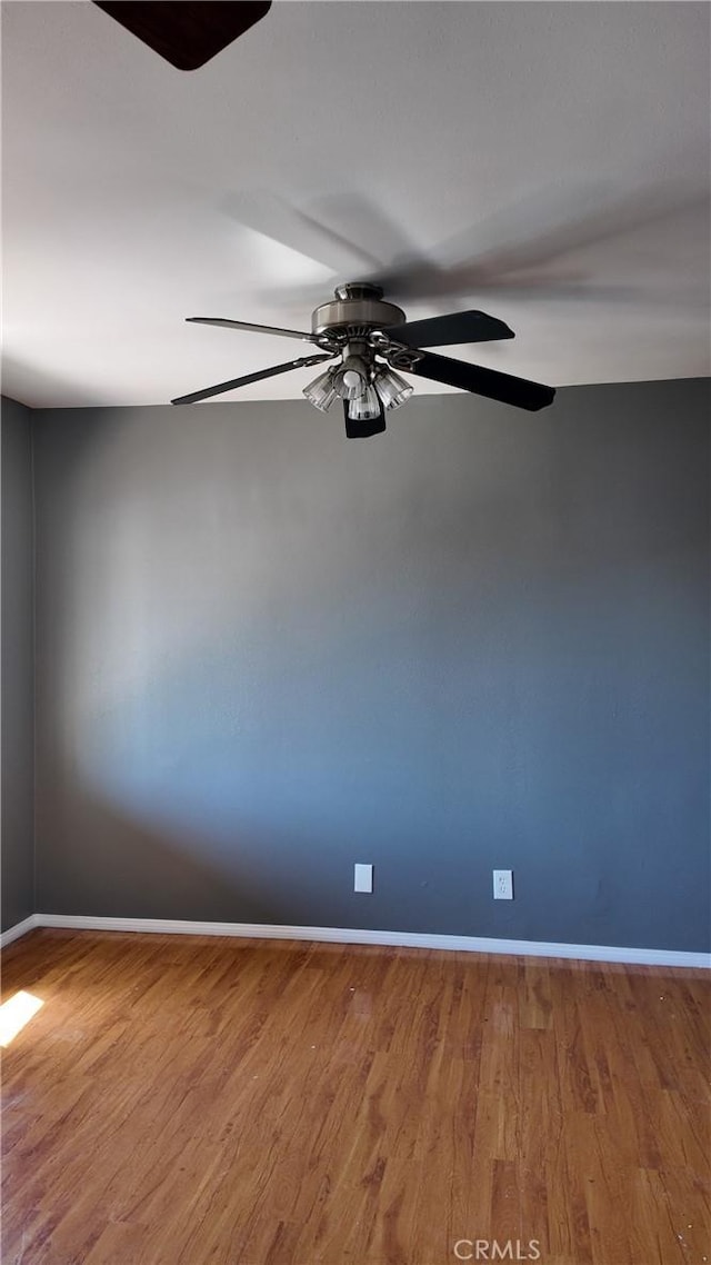 unfurnished room with wood finished floors, ceiling fan, and baseboards